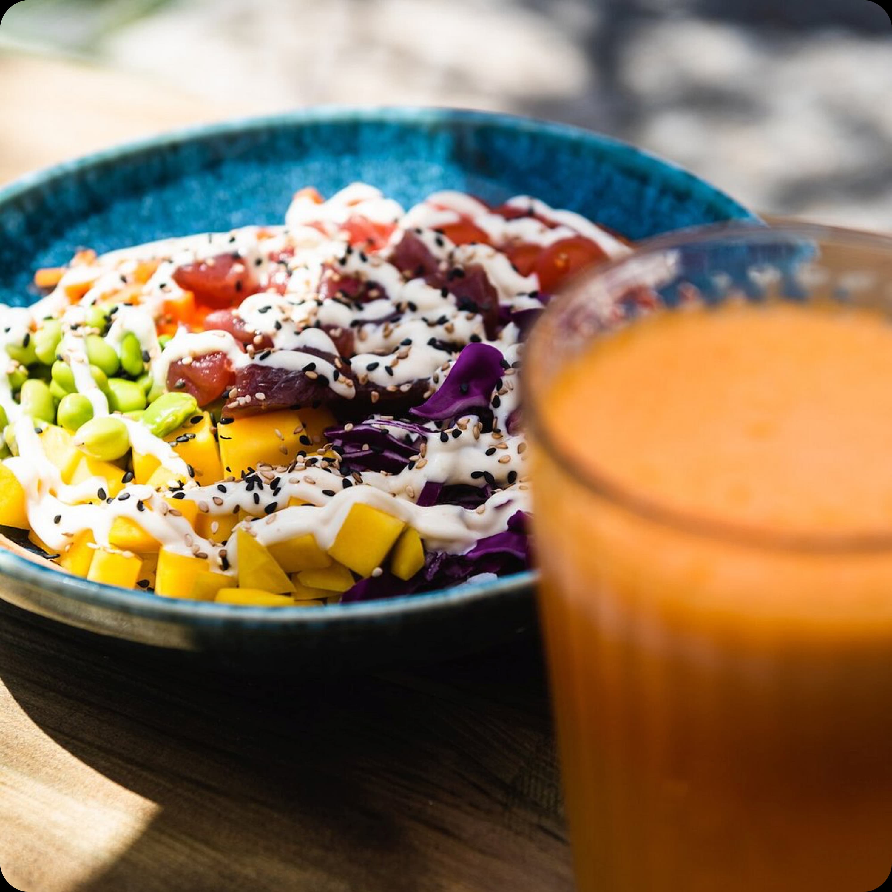 A vibrant, healthy salad bowl and a glass of fresh orange juice, photographed up close.
